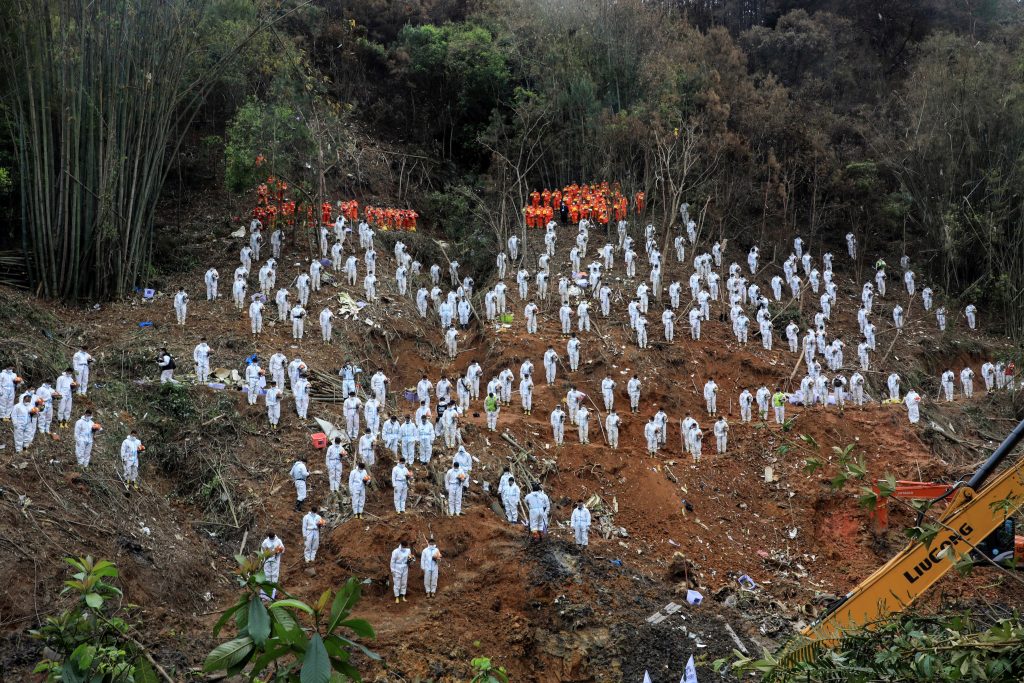 Rescue workers stand in a silent tribute at the site to mourn the victims of a China Eastern Airlines Boeing 737-800 plane, flight MU5735, that crashed in Wuzhou, Guangxi Zhuang Autonomous Region, China