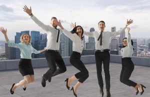 Diverse group of employees collaborating in a well-lit office space, emphasizing workplace wellbeing and inclusivity.