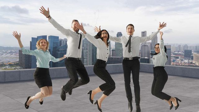 Diverse group of employees collaborating in a well-lit office space, emphasizing workplace wellbeing and inclusivity.