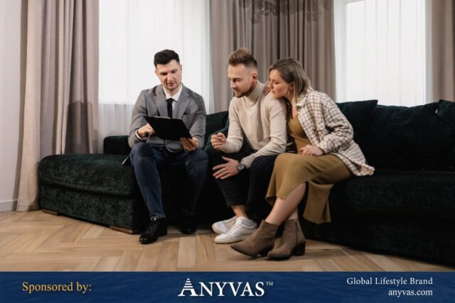 A business professional presenting a document to a couple seated on a sofa, showcasing personalized consultation in a home setting. Sponsored by ANYVAS™, a global lifestyle brand.