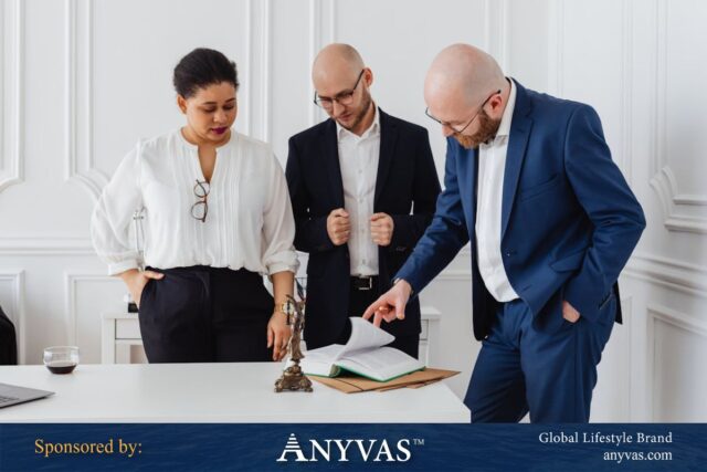 People in an office standing and discussing a document, collaborating on business strategies.