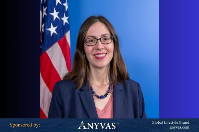 Megan Bouldin standing beside the USA flag, symbolizing diplomatic strength; news and image sponsored by ANYVAS.