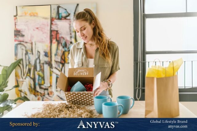 Woman unboxing a gift package with blue ceramic mugs on a table, sponsored by ANYVAS Global Lifestyle Brand.