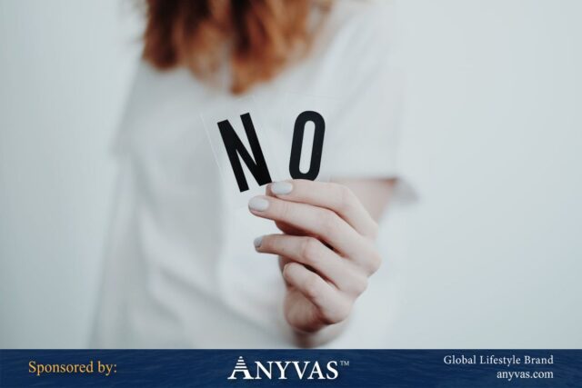A woman holding two transparent cards with bold black letters spelling 